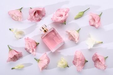 Luxury perfume and floral decor on white background, flat lay