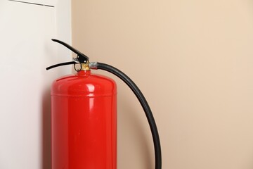 One fire extinguisher near beige wall indoors