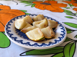 Abiu fruit cut into pieces on white porcelain plate with blue details