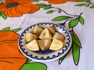 Abiu fruit cut into pieces on white porcelain plate with blue details