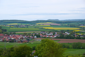 a beautiful view across landscape and yellow blooming files of rape in Duderstadt, Germany
