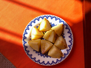 Abiu fruit cut into pieces on white porcelain plate with blue details