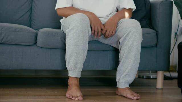 Person is Sitting in Sofa and Nervously Shaking Legs. Close-up. Mental Health Problems.