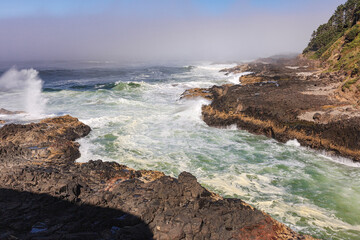 Coastal fog and crashing waves on the rocky central Oregon coast , USA.
