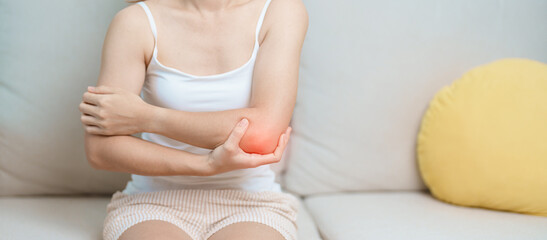 Woman having elbow ache at home, muscle pain due to lateral epicondylitis or tennis elbow. injury,...