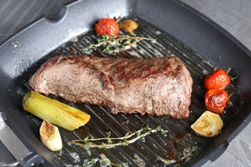 Delicious grilled beef meat and vegetables in pan on table, closeup
