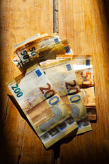 euro bills on a table in a strip of light.Income in European countries. Euro currency banknotes...