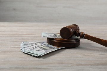 Judge's gavel and money on wooden table