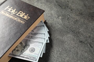 Holy Bible and money on grey table, closeup. Space for text