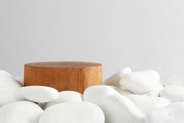 Presentation for product. Wooden podium and white pebbles on light background. Space for text