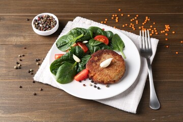 Tasty vegetarian cutlet served with vegetables on wooden table
