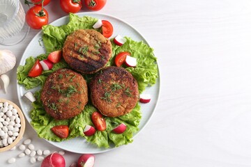 Delicious vegetarian cutlets served on white wooden table, flat lay. Space for text