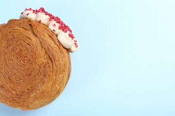 One supreme croissant with cream on light blue background, top view with space for text. Tasty puff...