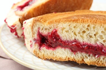 Round croissant with jam on table, closeup. Tasty puff pastry