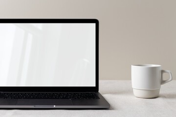 Empty computer laptop screen, modern home interior, cup of coffee