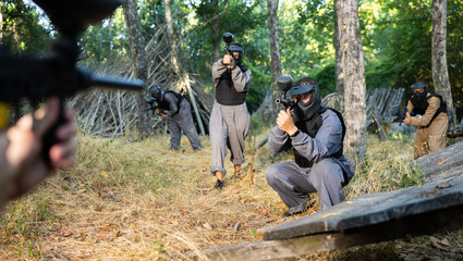 Fototapeta premium Impudent teams facing on battlefield in outdoor paintball arena during the match