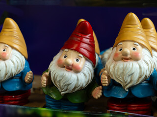 Selective focus view of rows of cute funny decorative garden gnomes on shelf