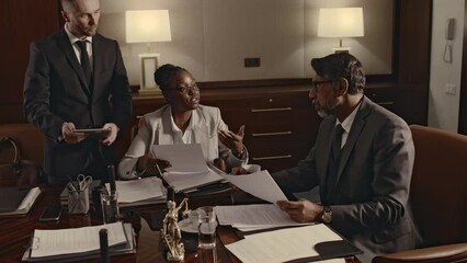Side footage of diverse male and female lawyers consulting law firm manager on previous legal cases during conference in boardroom
