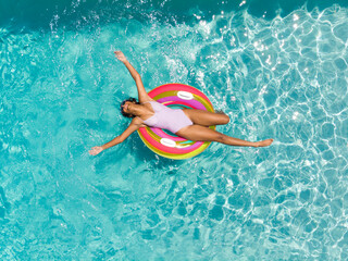 Naklejka premium Teenage biracial girl enjoys a sunny day in the pool