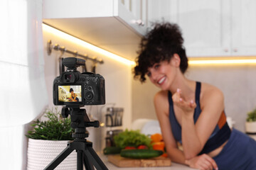 Food blogger explaining something while recording video in kitchen, focus on camera