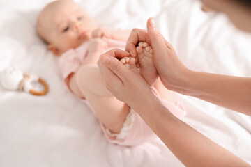 Mother with her cute little baby on white sheets, selective focus