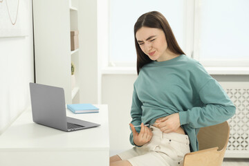 Diabetes. Woman making insulin injection into her belly at table indoors