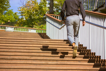 Business man in business style climbing confidently up wooden steps Success, extension forward...