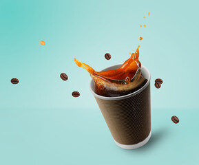 Aromatic coffee splashing in takeaway paper cup and flying roasted beans on turquoise background