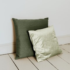 Green cushions on white wooden floor, aesthetic home decor