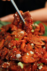 젓가락으로 집은 양념 족발