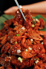 젓가락으로 집은 양념 족발