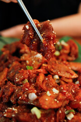 젓가락으로 집은 양념 족발