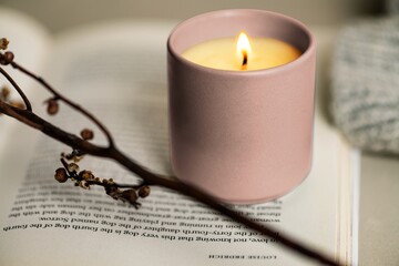 Lit aromatherapy scented candles on a book
