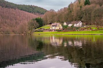 a house is on the water with a house in the background Germany EinRuhr