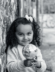 Portrait of a young girl holding a disco ball
