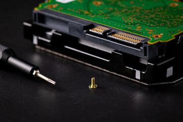 Hard disk drive and printed circuit board with SATA power connector. Magnetic driver torx bit and small machine screw - Powered by Adobe