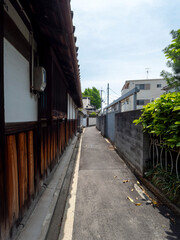 板塀の古い建物が並ぶ路地の風景