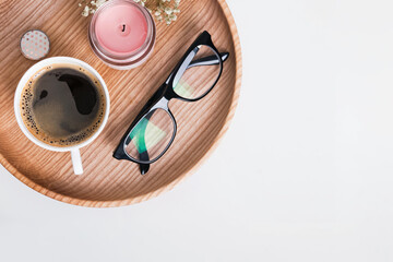 Morning Coffee, candle and reading glasses on the wooden tray, top view