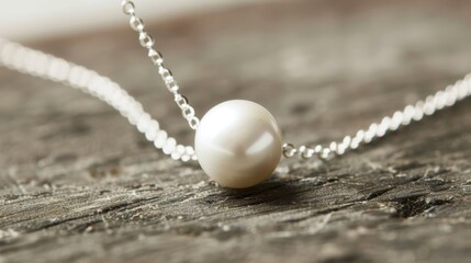 A minimalist necklace featuring a single freshwater pearl on a thin silver chain.