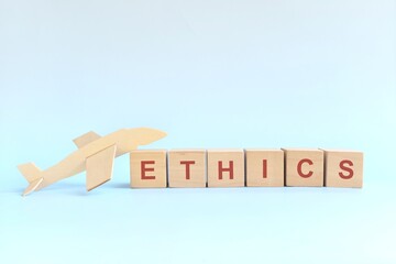 Air travel ethics concept. Wooden blocks typography with airplane model.