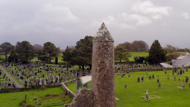 Dynamic aerial shot of Clonmacnoise, highlighting cemetery and round tower