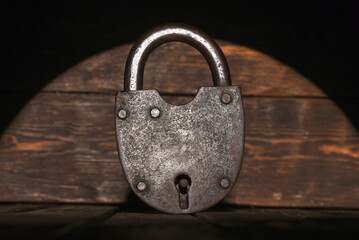 Old  barn padlock on the wooden desk table background close up. Secret information concept. Looking...