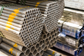 A neat stacked shipment of GI metal pipes delivered for shipping at the port.