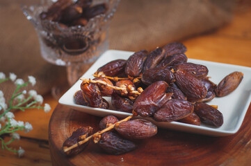 a cup of tea with date fruits lay on wooden table. It' the best dish for breaking fast during...