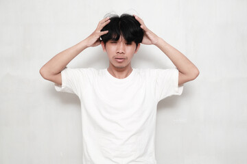 Young Asian man wearing white t-shirt showing frustrated gesture