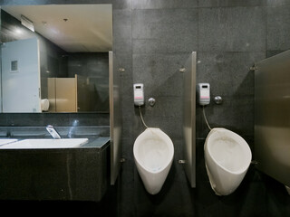 A bathroom with two urinals and a sink