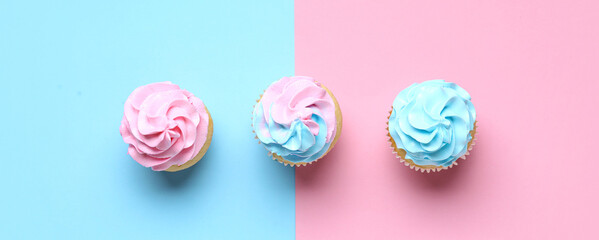 Delicious cupcakes with blue and pink frosting on color background. Gender reveal party concept