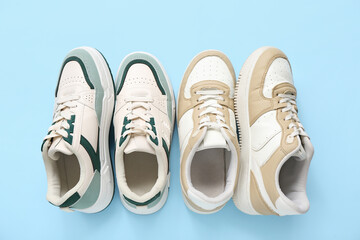 Different stylish sneakers on blue background