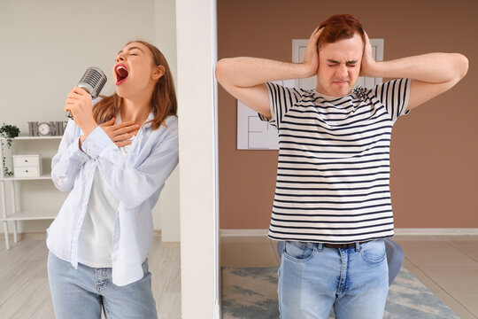 Young man suffering from loud neighbour singing at home