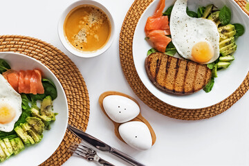 Healthy Breakfast bowls with salmon, avocado, toast and eggs, top view